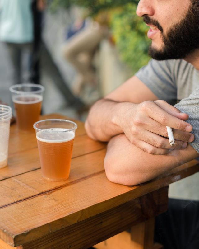 Vīrietis dzer alu un smēķē/ Photo by Diego Indriago from Pexels