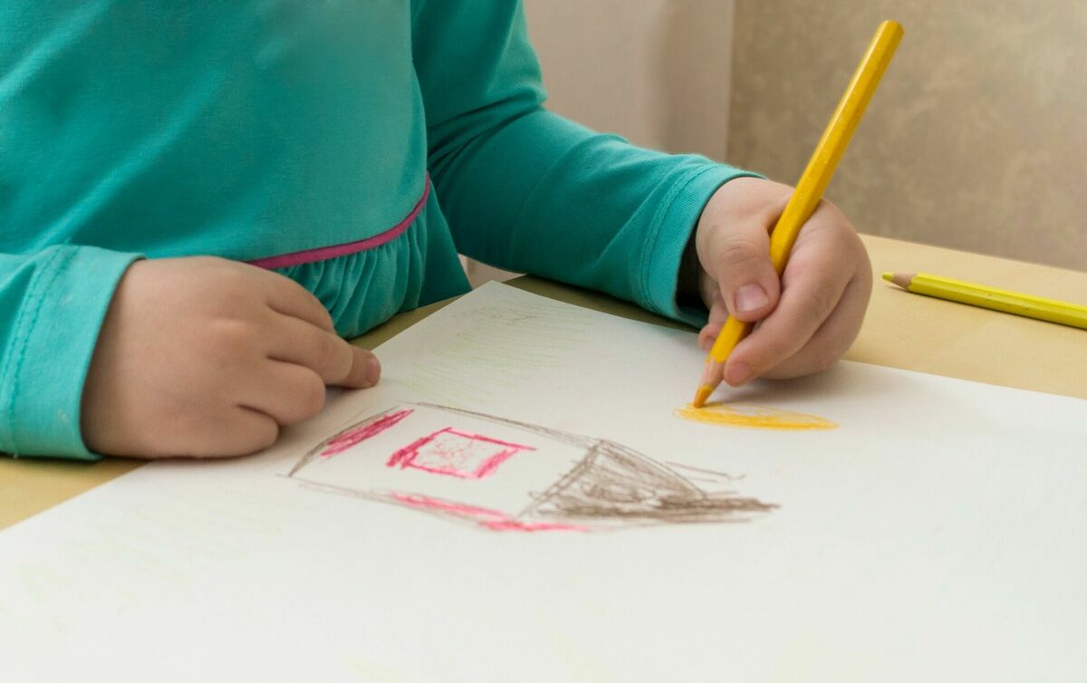 Bērns zīmē ar krieso roku. Foto: Pexels