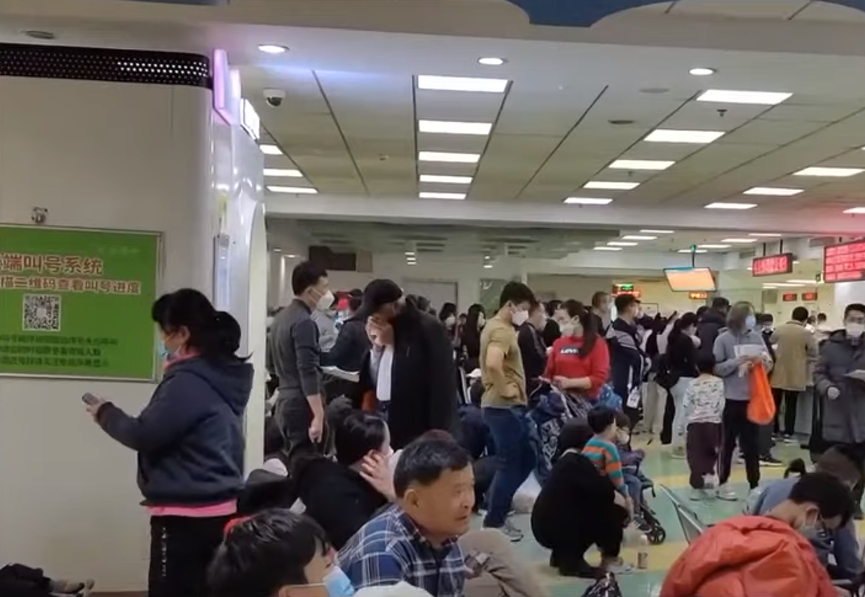 Pēdējās dienās vietējie mediji tādās ziemeļrietumu pilsētās kā Sjaņa ir publicējuši internetā videomateriālus, kuros redzamas slimnīcas - pārpildītas ar vecākiem un bērniem, kas gaida, lai viņus pieņemtu mediķi. Foto: NTD/YouTube