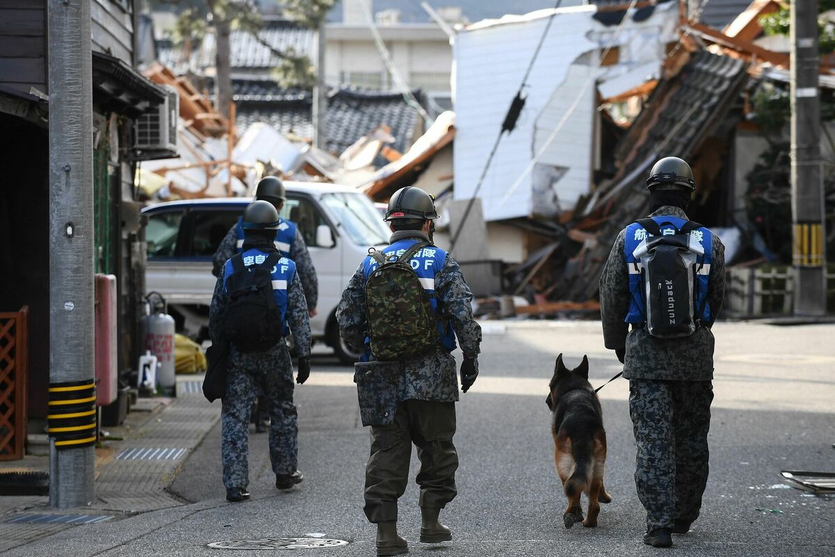 Karavīri pastaigājas ar suni, lai meklētu zemestrīces upurus Vadžimas pilsētā, Išikavas prefektūrā, 5. janvārī. Foto: Toshifumi KITAMURA / AFP
