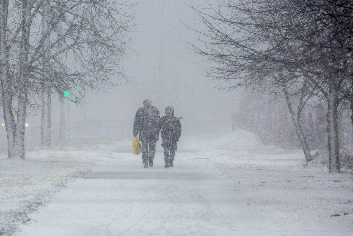 Cilvēki uz ielas sniegputeņa un vētras laikā. Foto: Edijs Pālens/LETA