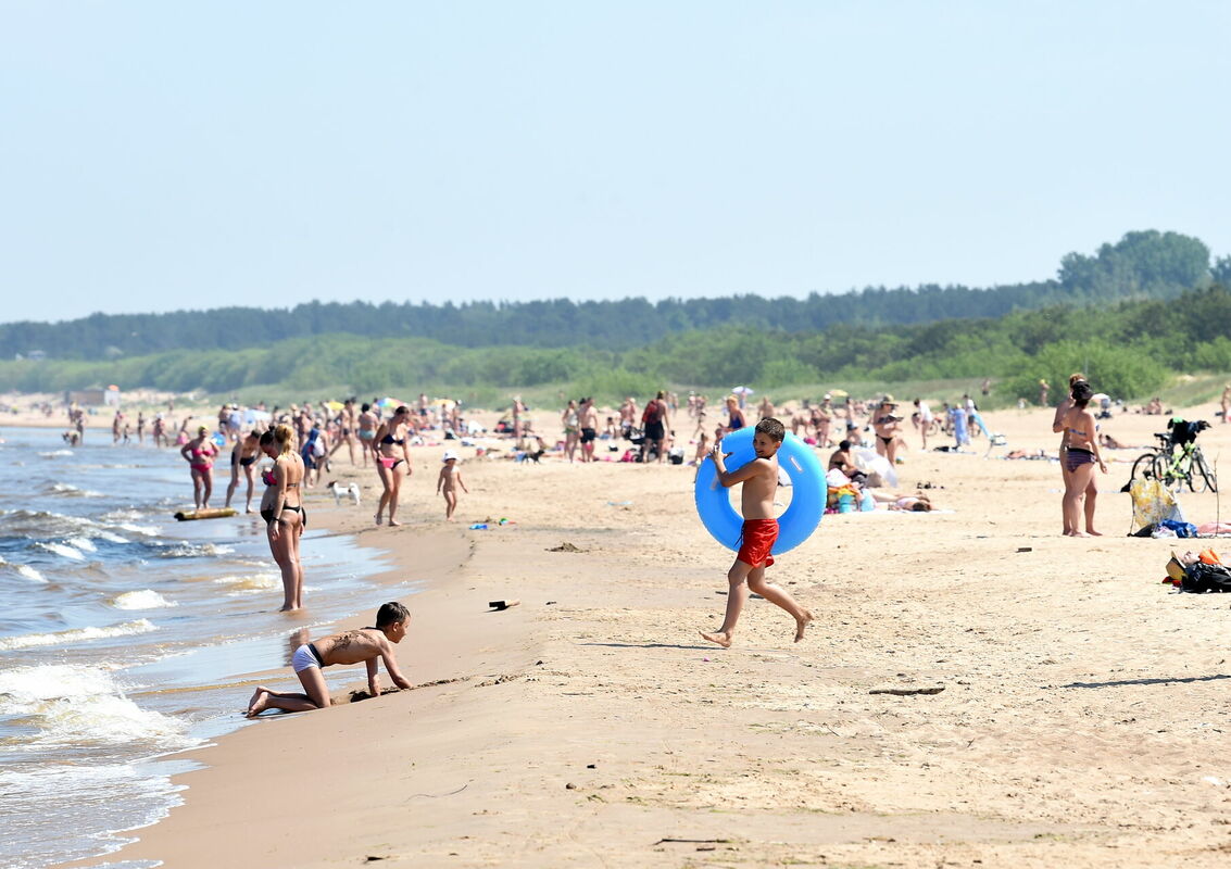 Cilvēki atpūšas Vecāķu pludmalē. Foto: Zane Bitere/LETA