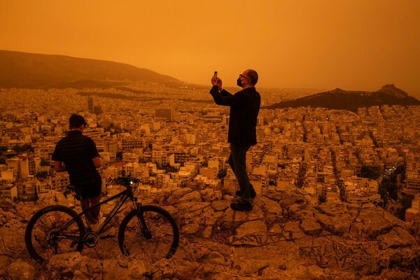 24. aprīlī virs Grieķijas galvaspilsētas Atēnām izviedojusies oranža migla Sahāras tuksneša putekļu dēļ. Foto: Angelos TZORTZINIS / AFP
