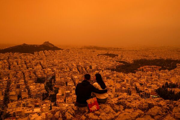 24. aprīlī virs Grieķijas galvaspilsētas Atēnām izviedojusies oranža migla Sahāras tuksneša putekļu dēļ. Foto:Angelos TZORTZINIS / AFP