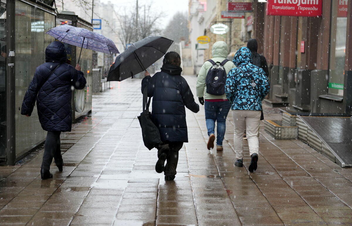 Cilvēki sniegputeņa laikā Merķeļa ielā. Foto: Zane Bitere/LETA