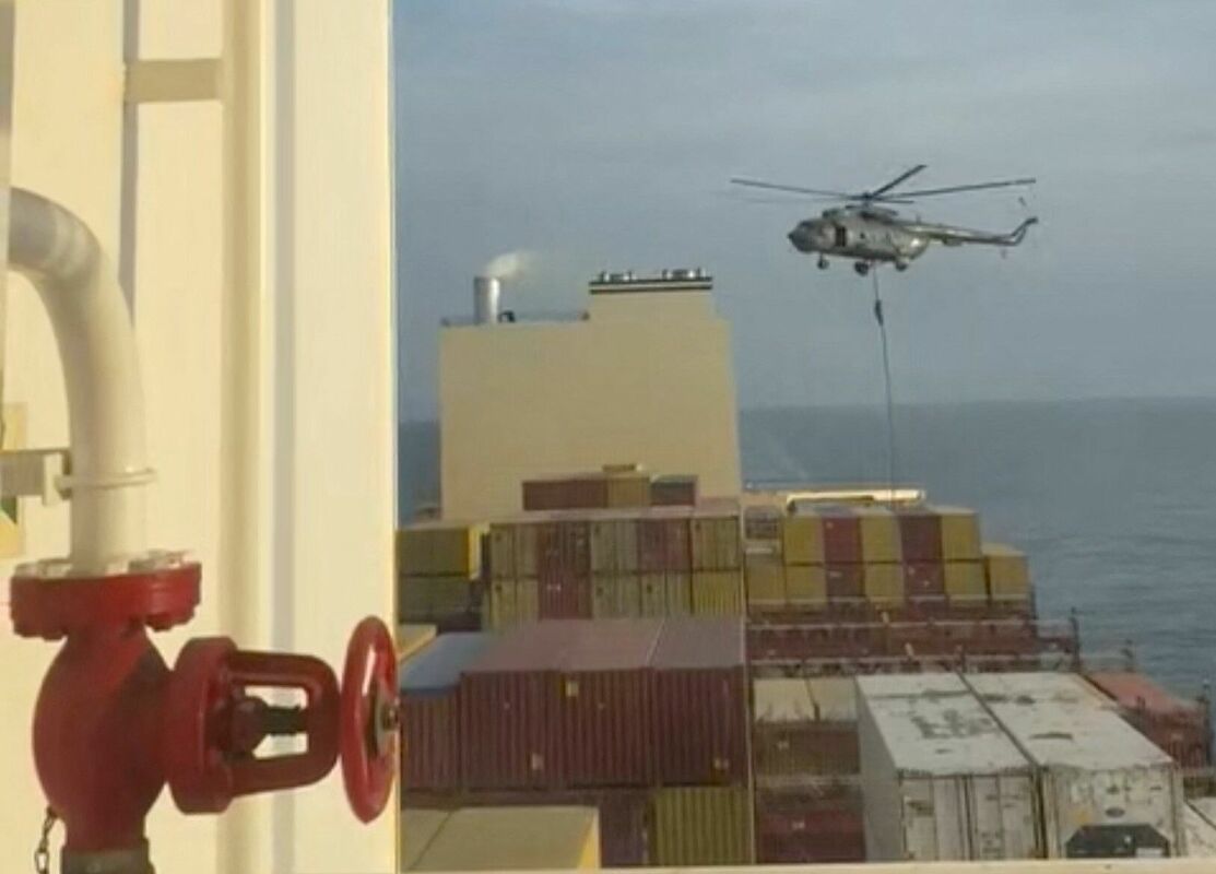 Cilvēks slīd lejup pa virvi helikoptera reida laikā uz MSC Aries kuģa jūrā šajā ekrānšāviņā, kas iegūts no 13. aprīlī sociālajos medijos publicētā video. Foto: Reuters