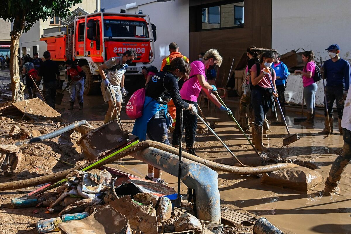 Brīvprātīgie palīdz ugunsdzēsējiem pilsētas uzkopšanas darbos. Foto: JOSE JORDAN / AFP / Scanpix