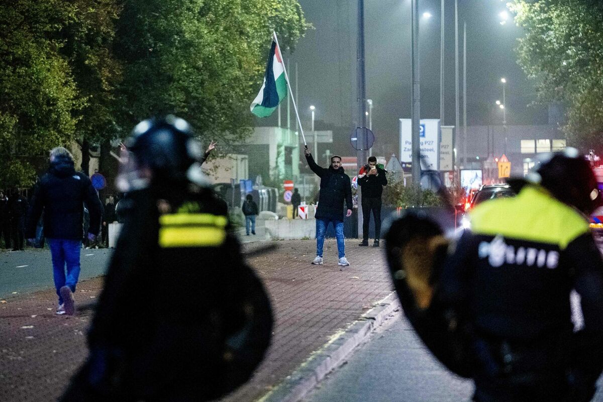 Līdzjutējs vicina palestīniešu karogu mobilās vienības policistu priekšā palestīniešus atbalstošas demonstrācijas laikā pie UEFA Eiropas līgas futbola spēles starp Amsterdamas “Ajax Amsterdam” un “Maccabi Tel Aviv” Amsterdamā, 7. novembrī. Foto: Jeroen Jumelet / ANP / AFP