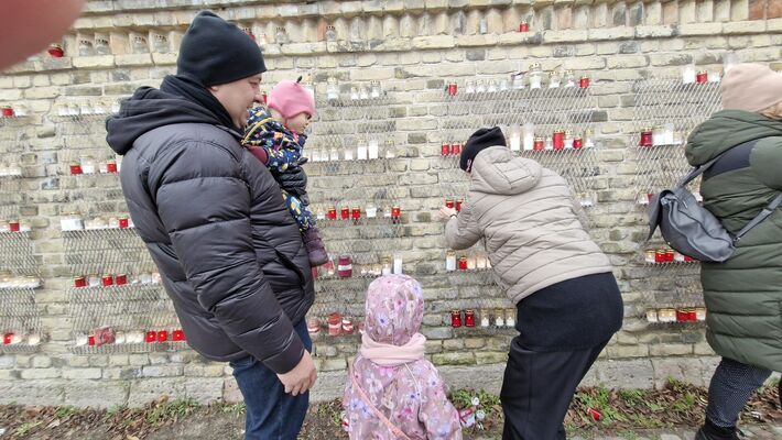 Par godu Lāčplēša dienai, cilvēki noliek svecītes pie Rīgas pils mūra. Foto: 360 ZIŅneši