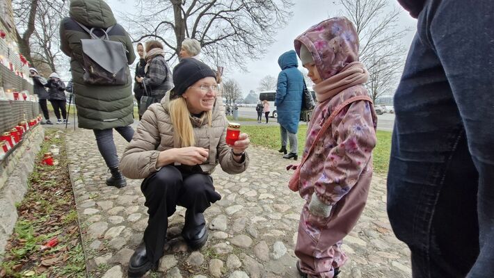 Par godu Lāčplēša dienai, cilvēki noliek svecītes pie Rīgas pils mūra. Foto: 360 ZIŅneši