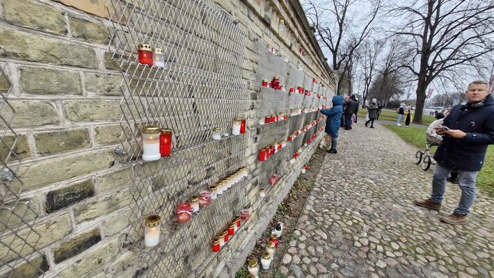 Par godu Lāčplēša dienai, cilvēki noliek svecītes pie Rīgas pils mūra. Foto: 360 ZIŅneši