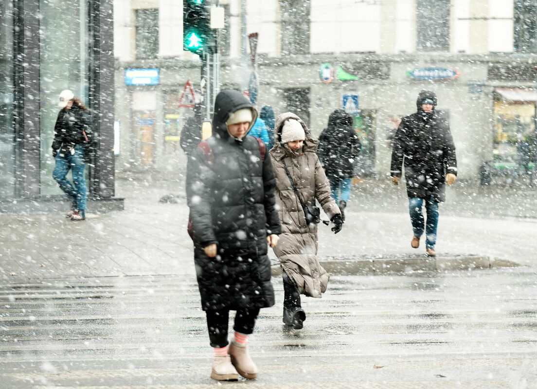 Cilvēki sniegputeņa laikā Satekles ielā. Foto: Lita Millere/LETA