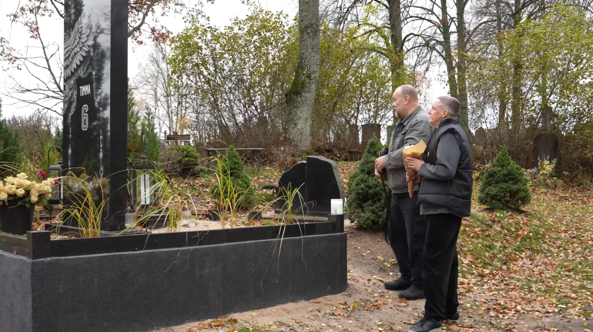 Raitis Timma un Edgars Jaunups pie Jāņa Timmas kapa vietas. Foto: Ekrānšāviņš no "VEF Rīga" podkāsta