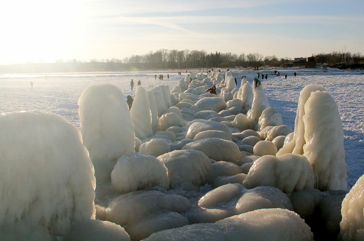 Cilvēki pie apledojuša Engures mola ziemā. Foto: Evija Trifanova/LETA