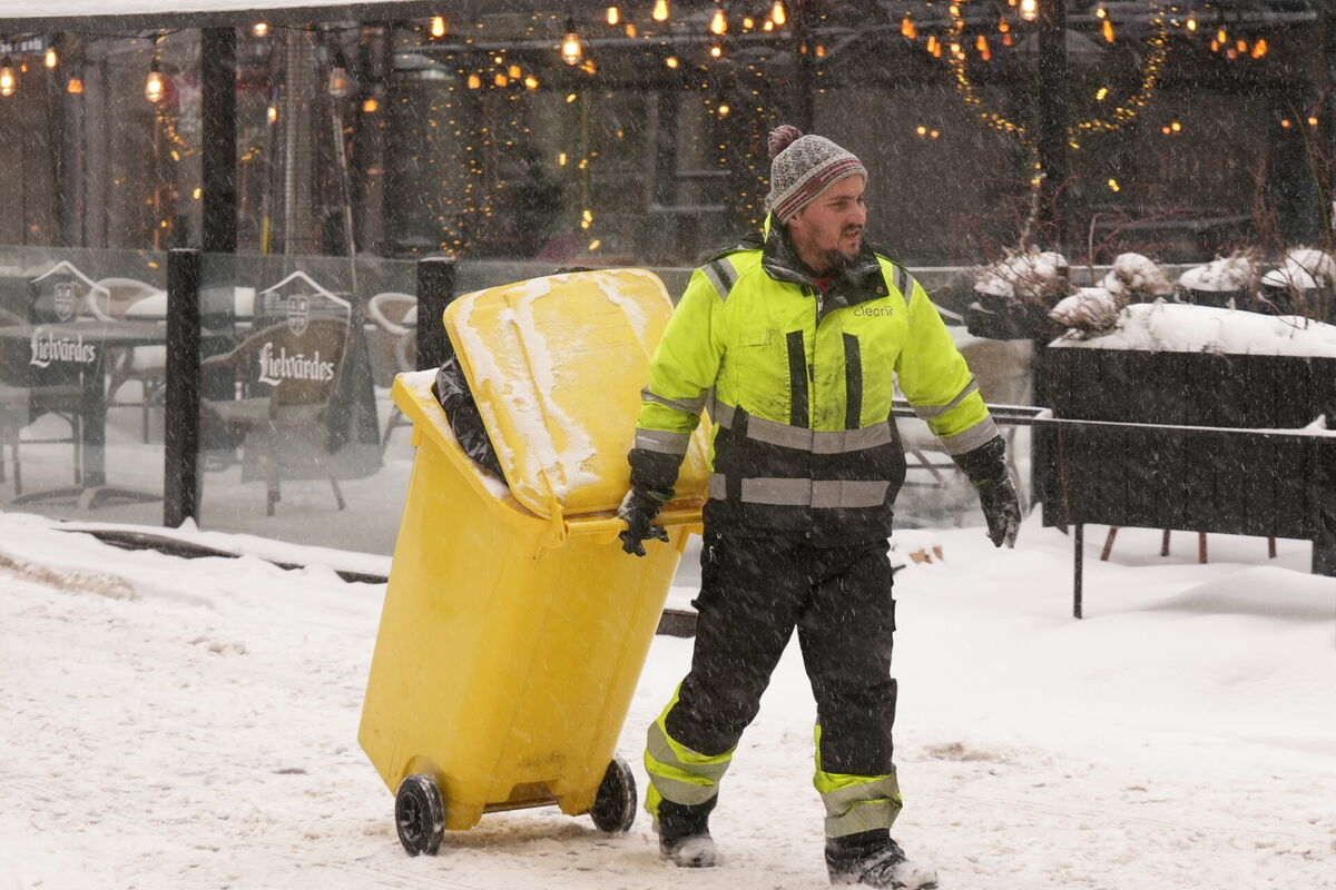 Vīrietis ar atkritumu konteineri. Foto: LETA